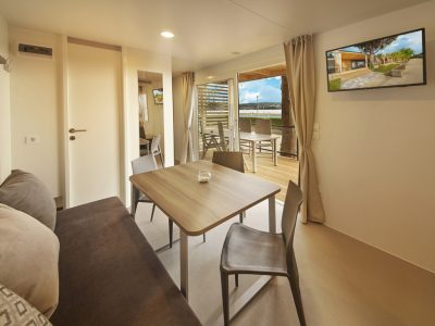 campsite-adria-ankaran-mobile-home-premium-interior-living-room-tv-view-on-terrace